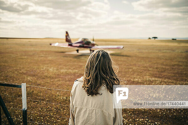 Woman looking at propeller airplane during weekend