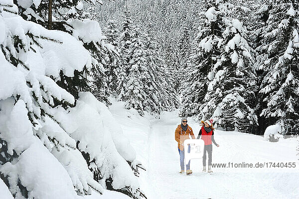 Woman walking with man on snow during winter