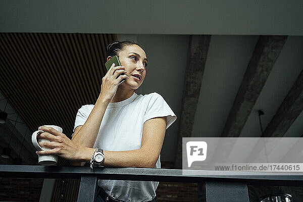 Female professional talking on mobile phone in office