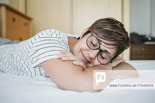 Frau mit geschlossenen Augen entspannt sich zu Hause im Bett