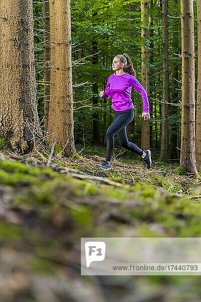 Female athlete running in forest