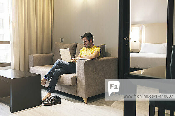 Businessman using laptop in hotel room