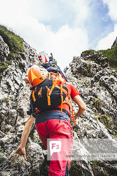 Männliche Wanderer klettern auf felsigen Berg