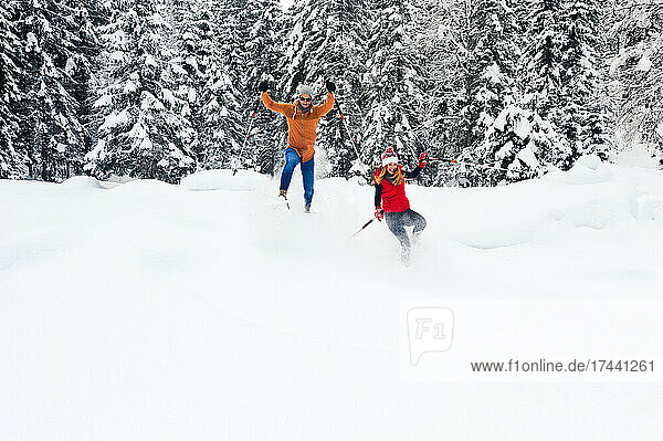Mitte erwachsenes Paar mit Wanderstock beim Schneeschuhwandern im Winter