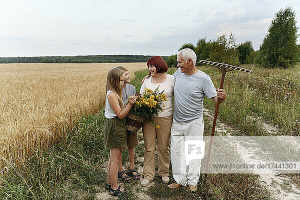 Grandparent and children with tansy flowers at field