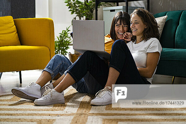 Happy women using laptop in living room