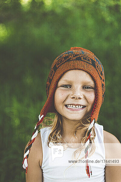 Happy girl wearing knit hat in summer