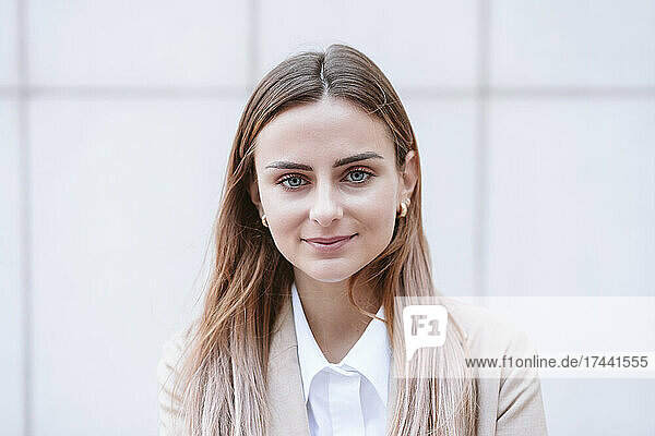 Female business professional in front of white wall