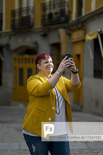 Übergewichtige Frau macht Selfie mit Handy auf Fußweg