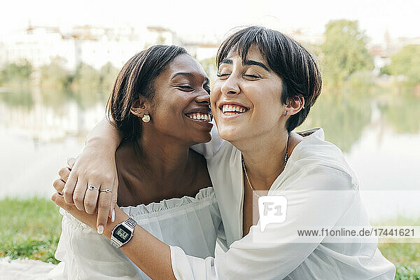 Cheerful women laughing at lakeshore