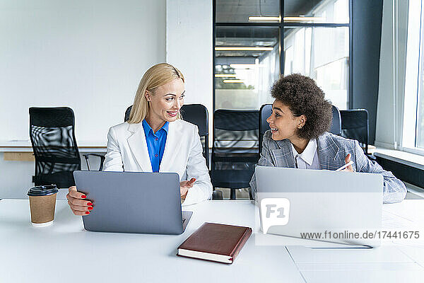 Businesswomen with laptop having discussion in office