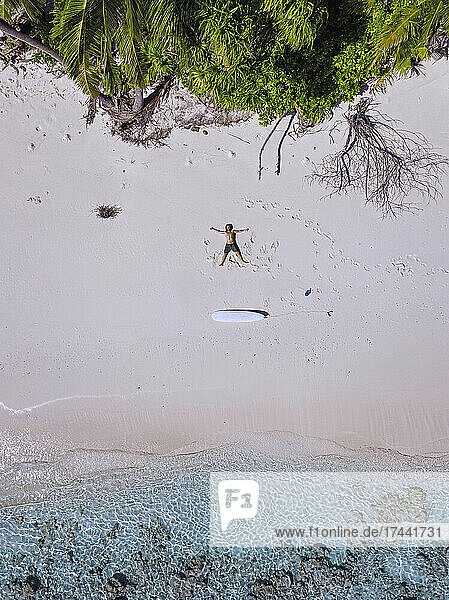 Man with arms outstretched relaxing on beach