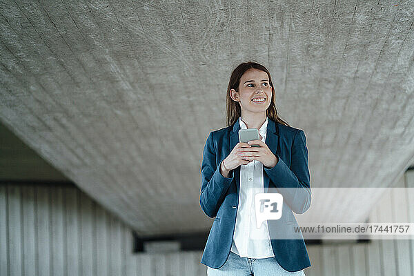 Female professional holding mobile phone at basement