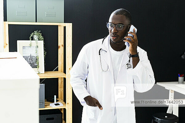 Male healthcare worker talking on smart phone at medical clinic