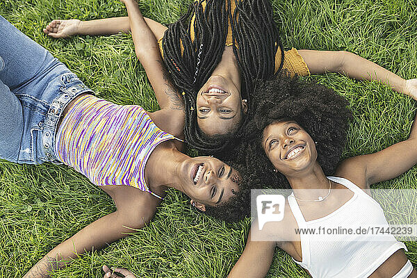 Young female friends lying on grass