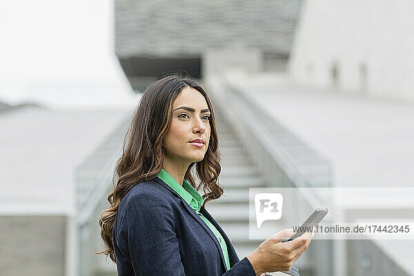Young female professional holding smart phone