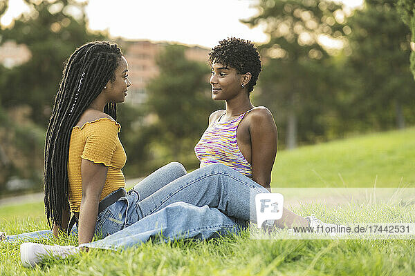 Lesbian women falling in love while sitting on grass