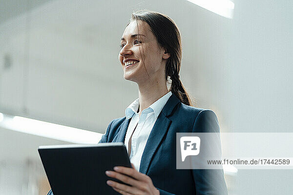 Female business professional with digital tablet in industry
