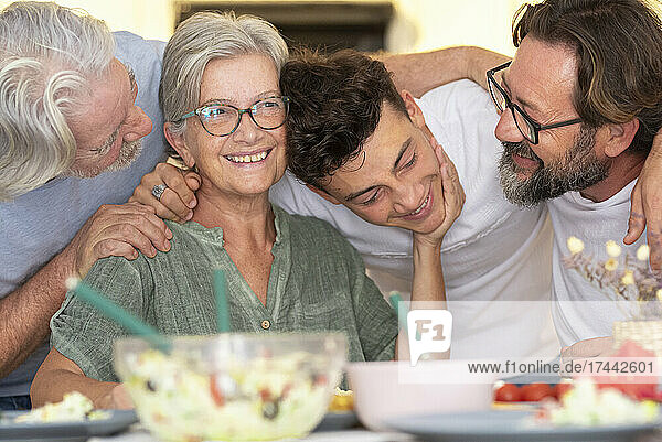 Happy family with arm around each other at dining table