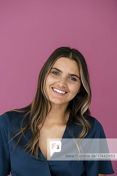 Young businesswoman in front of pink color wall