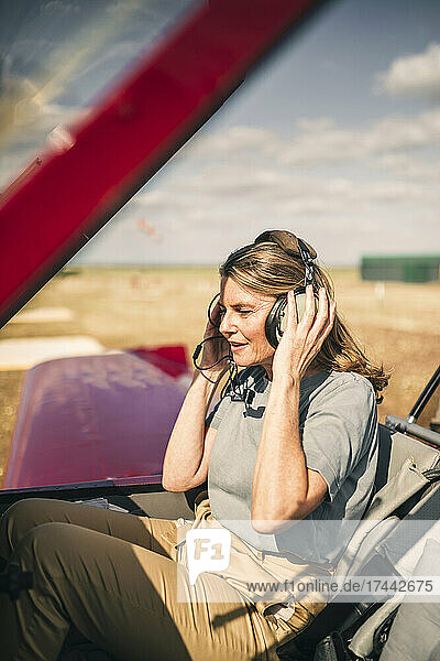 Woman listening through headphones in airplane