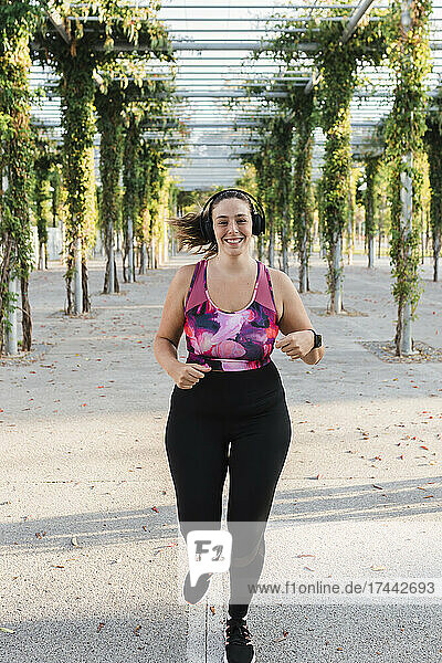 Smiling sportswoman running in park