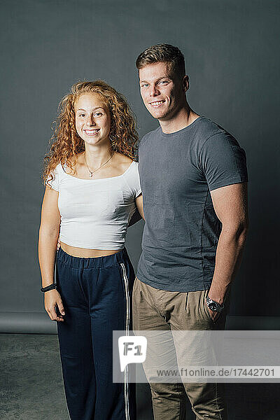 Smiling young couple standing together in studio