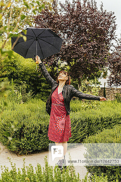 Woman with umbrella enjoying rainy day at park
