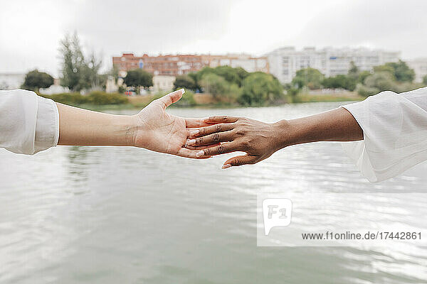 Lesbische Frauen berühren sich am See die Hände