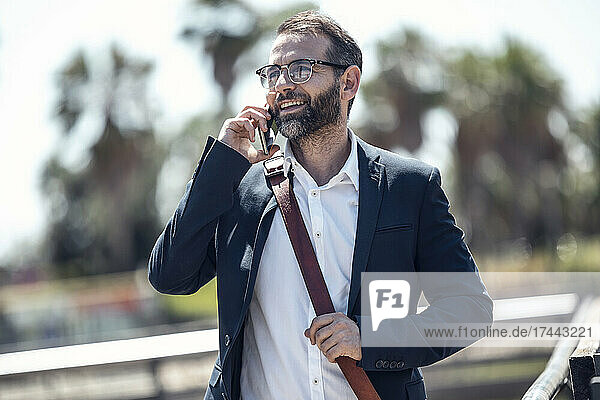Male professional talking on mobile phone during sunny day