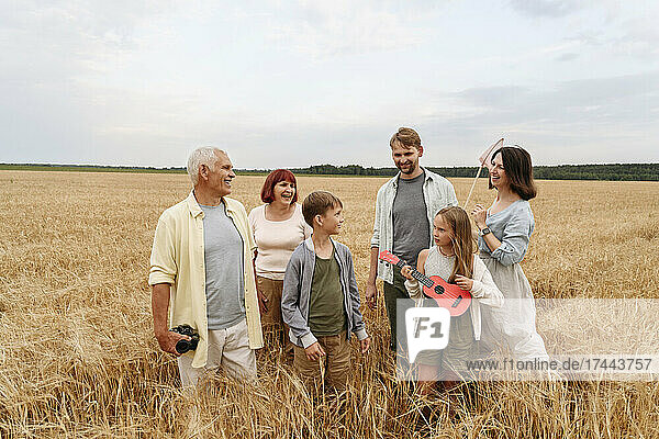Happy family standing together in wheat field