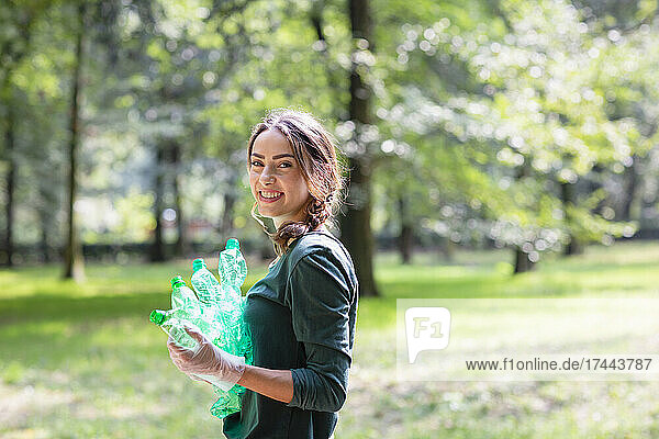 Female environmentalist holding plastic bottles at park