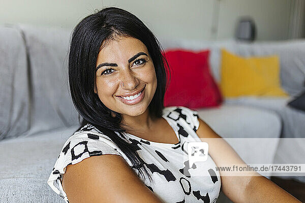 Smiling beautiful woman sitting in living room