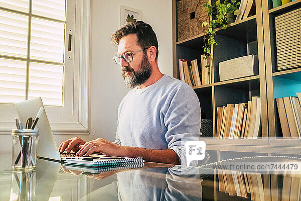 Mature businessman working on laptop at home