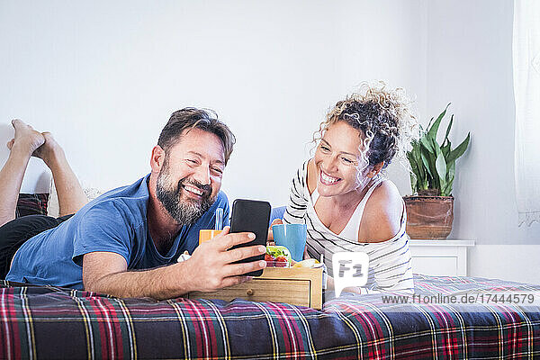 Couple having breakfast while attending video call through smart phone at home
