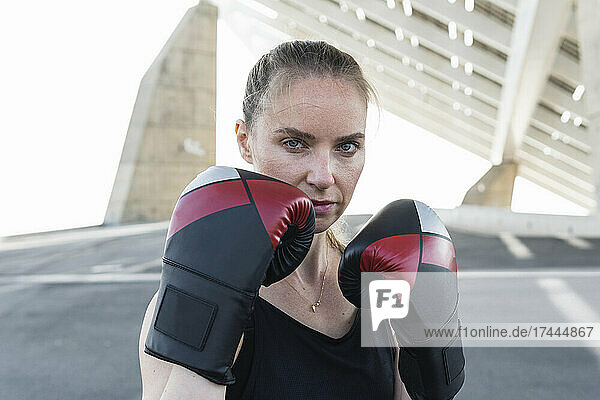 Serious female athlete with boxing glove