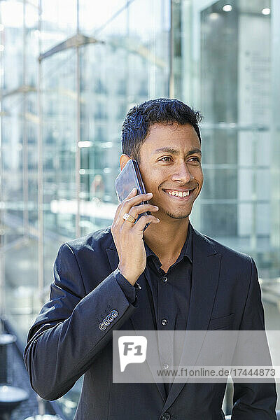 Happy male professional talking on mobile phone