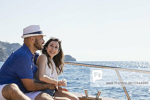 Couple enjoying motorboat ride during sunny day
