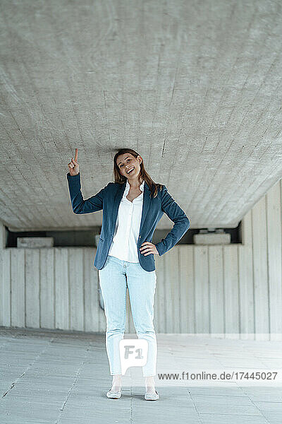 Cheerful businesswoman gesturing while standing at basement