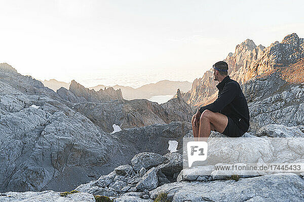 Male tourist looking at Picos de Europe mountain ranges at sunrise  Cantabria  Spain
