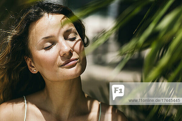 Mid adult woman with eyes closed during sunny day