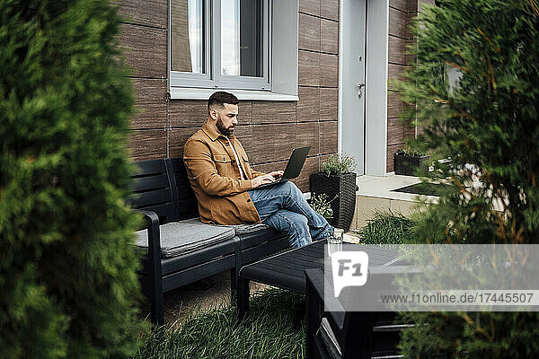 Businessman working on laptop at patio