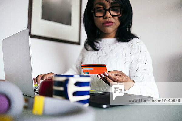 Businesswoman paying through credit card at home