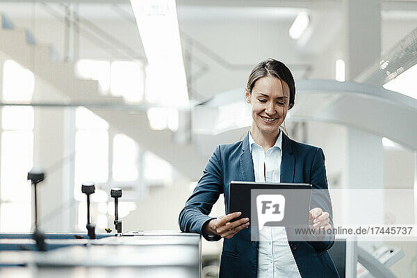 Female business professional using digital tablet in industry