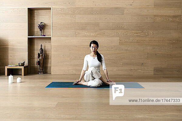 Asian woman practice yoga Gomukhasana or Cow Face pose to meditation