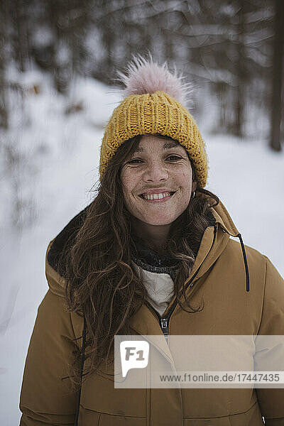 happy girl with freckles smiles in snow covered czech woods in winter