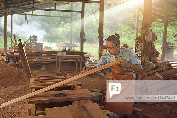 Carpenters using circular saw in workshop