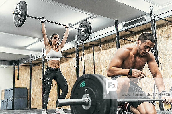 couple of man and woman doing weights in gym  crossfit