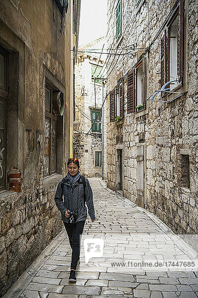 woman walking through cobble stone alley in Sibenik