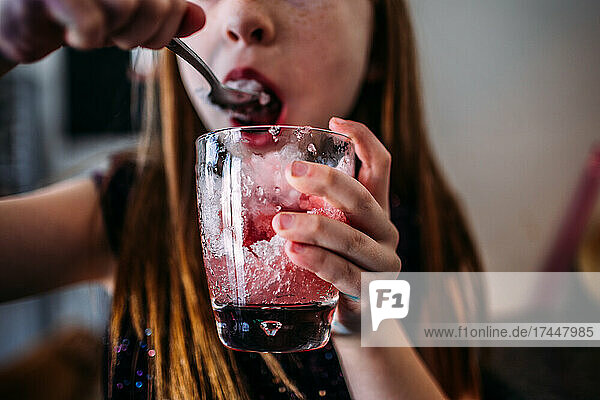 Young girl eating a home made snow cone